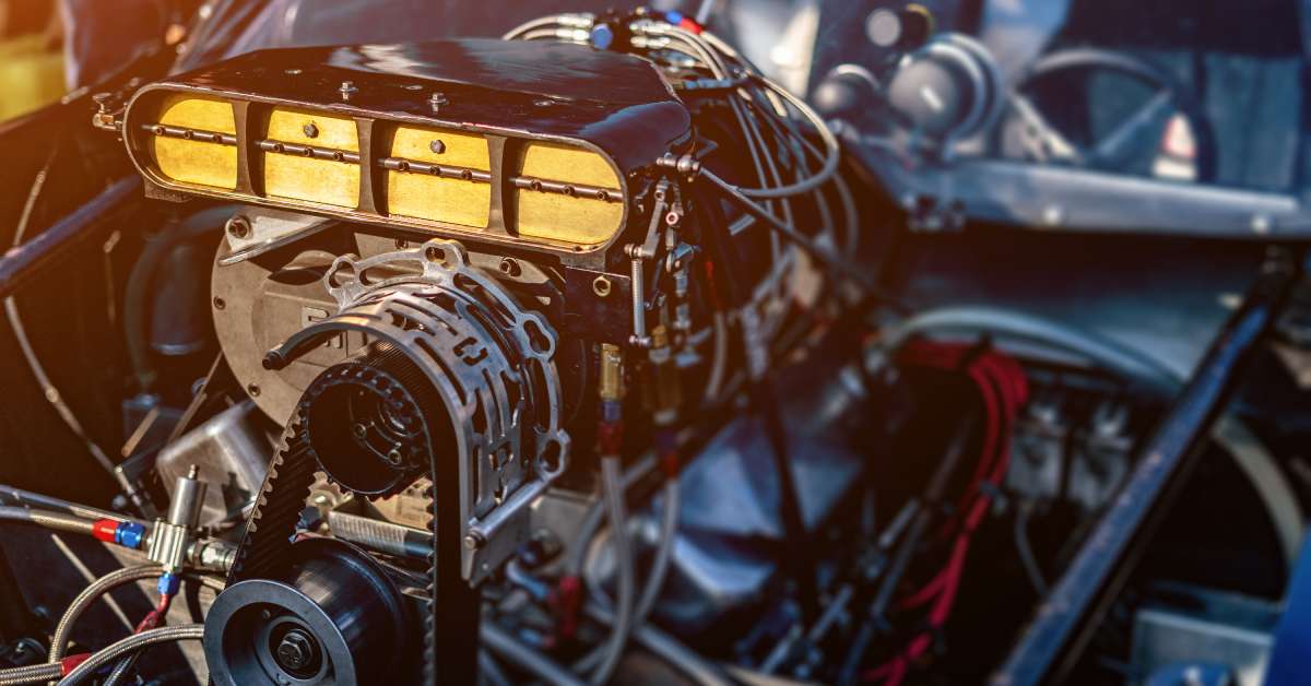 The engine bay inside a sports car. Wires and metal parts help keep the motor together to stay running on the race track.