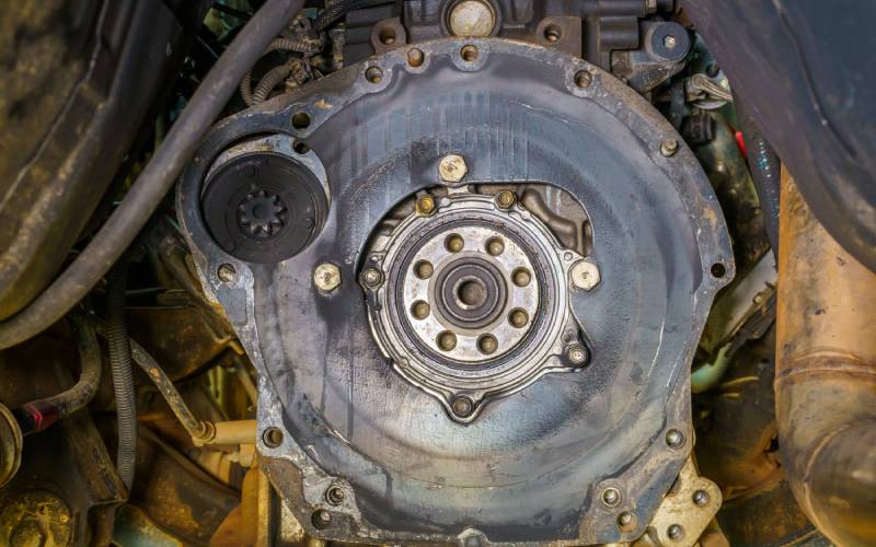 Close-up of a car engine's dirty and stained gasket. There is emphasis on the vehicle's oil seal.