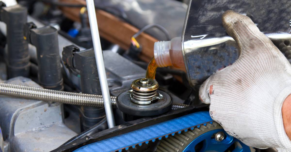 AA drag race car owner pours a specialized oil blend into their drag race car engine to improve its performance and extend longevity.